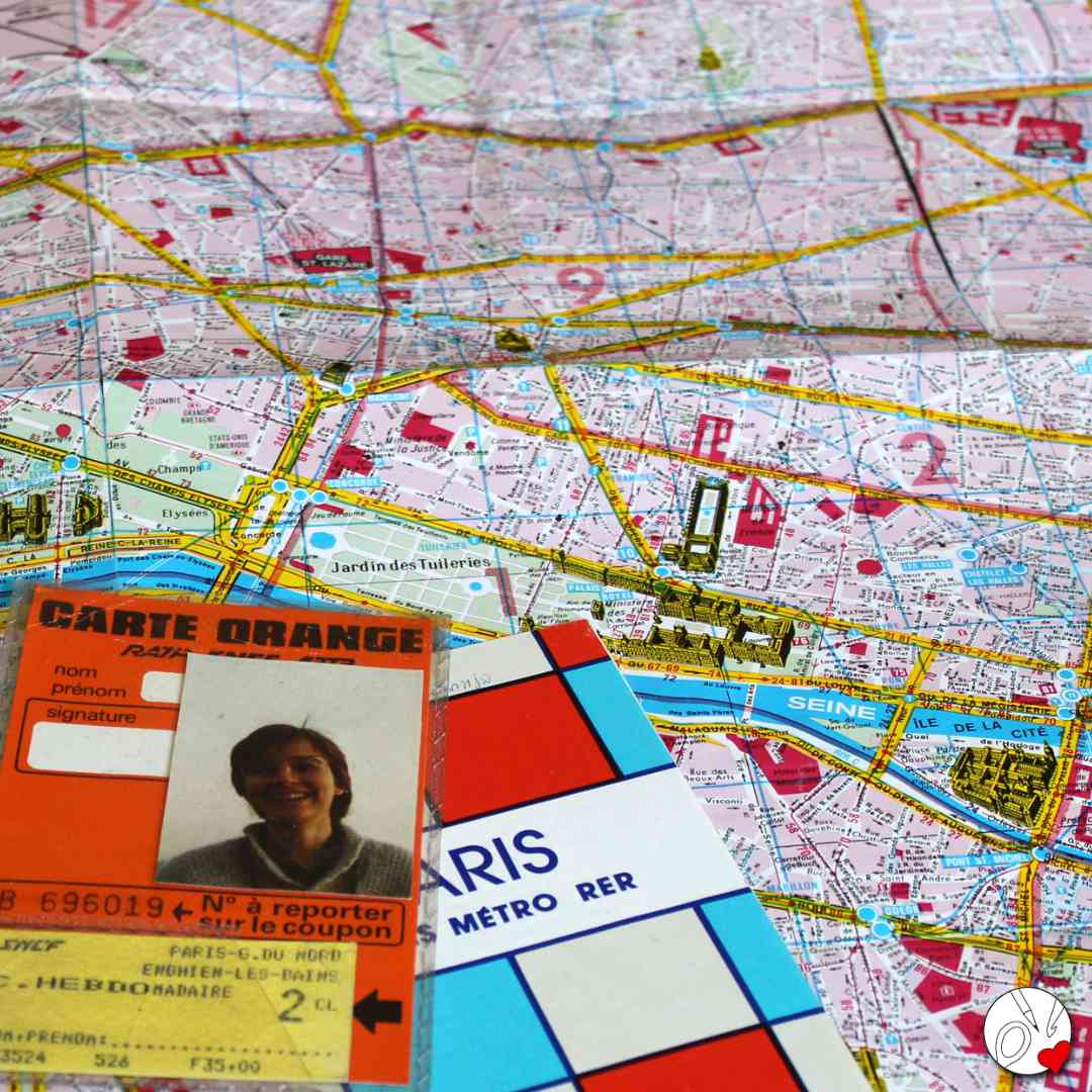 Auf einem Stadtplan von Paris liegt eine Carte Orange und ein Metroplan