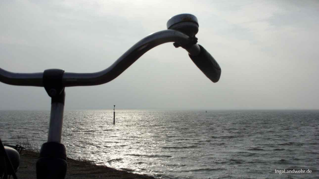 Fahrradlenker im Gegenlicht; Im Hintergrund ist die Nordsee