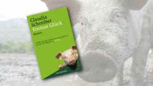 Buchcover von "Emmas Glück" im Vordergrund, Schweineschnauze rechts neben dem Cover
