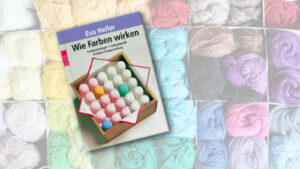 Buchcover von "Wie Farben wirken" im Vordergrung, im Hintergrund bunte Wollknäule