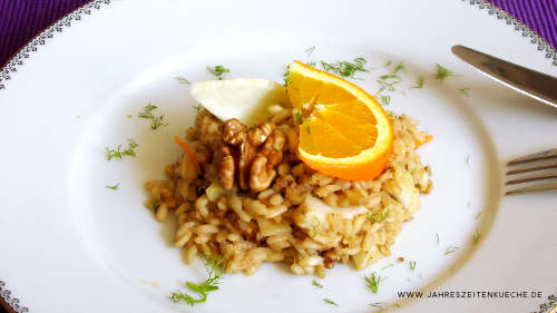 Veganes Winter-Risotto mit einer Orangenscheibe auf einem weißen Teller